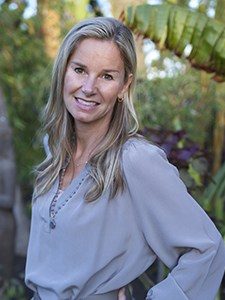Smiling woman in a garden setting.